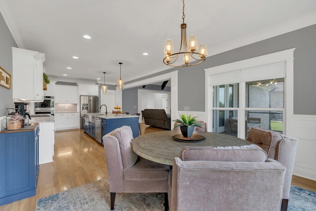 2732 Cherrydale Dr, Lebanon, TN 37087 - dining space featuring a chandelier, light wood finished floors, wainscoting, recessed lighting, and crown molding