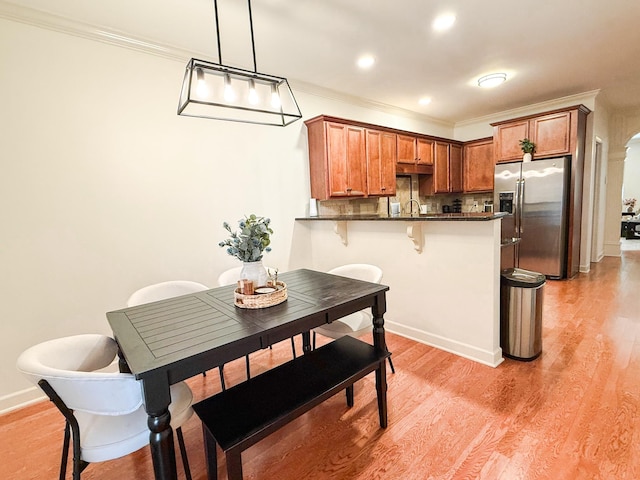 2138 Cason Ln, Murfreesboro, TN 37128 - kitchen featuring stainless steel refrigerator with ice dispenser, dark countertops, a peninsula, brown cabinets, and a breakfast bar area
