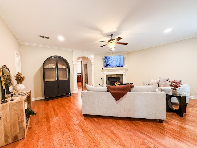 2138 Cason Ln, Murfreesboro, TN 37128 - living room featuring a ceiling fan, a fireplace, decorative columns, light wood-type flooring, and arched walkways