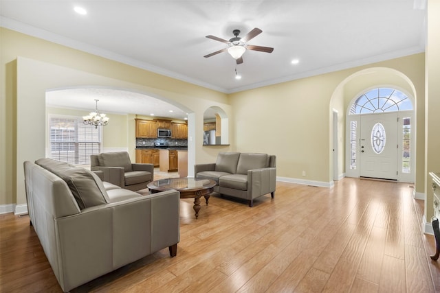 2240 Killington Dr, Clarksville, TN 37040 - living area featuring arched walkways, a chandelier, a ceiling fan, light wood-type flooring, and ornamental molding