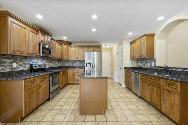 2240 Killington Dr, Clarksville, TN 37040 - kitchen featuring appliances with stainless steel finishes, a sink, a center island, tasteful backsplash, and dark stone counters