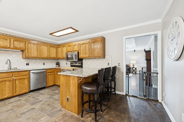 2118 Winthorne Ln, Murfreesboro, TN 37129 - kitchen featuring appliances with stainless steel finishes, a sink, stone finish floors, a peninsula, and ornamental molding