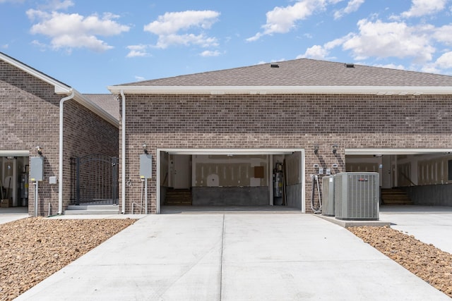 1079 Wrights Mill Rd Unit H8, Spring Hill, TN 37174 - view of side of property featuring concrete driveway, brick siding, central AC, and roof with shingles