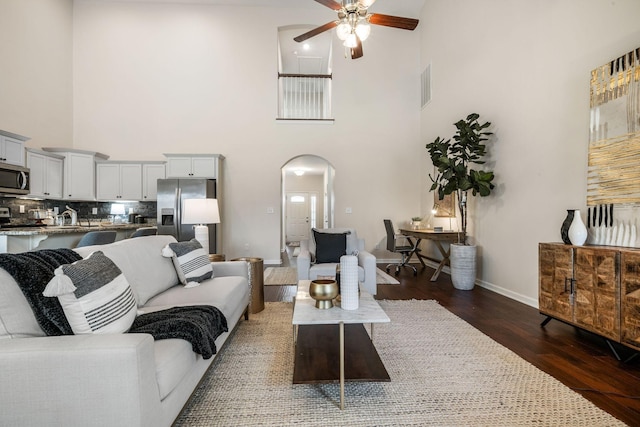 7504 Beechnut Way, Fairview, TN 37062 - living room with arched walkways, ceiling fan, a high ceiling, dark wood-style flooring, and baseboards
