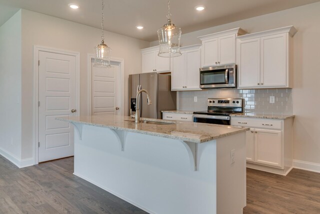 1075 Wrights Mill Rd Unit H-6, Spring Hill, TN 37174 - kitchen with stainless steel appliances, baseboards, dark wood-style floors, a kitchen island with sink, and decorative backsplash