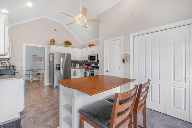 306 S Cameron Ct, Hermitage, TN 37076 - kitchen with stainless steel appliances, a ceiling fan, white cabinets, a breakfast bar, and backsplash