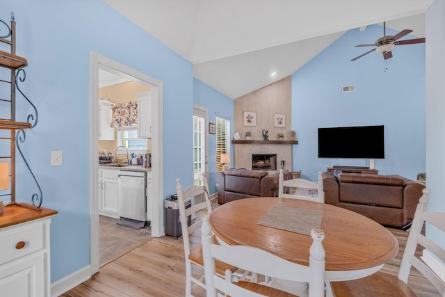 306 S Cameron Ct, Hermitage, TN 37076 - dining room featuring light wood-style floors, ceiling fan, a fireplace, high vaulted ceiling, and baseboards