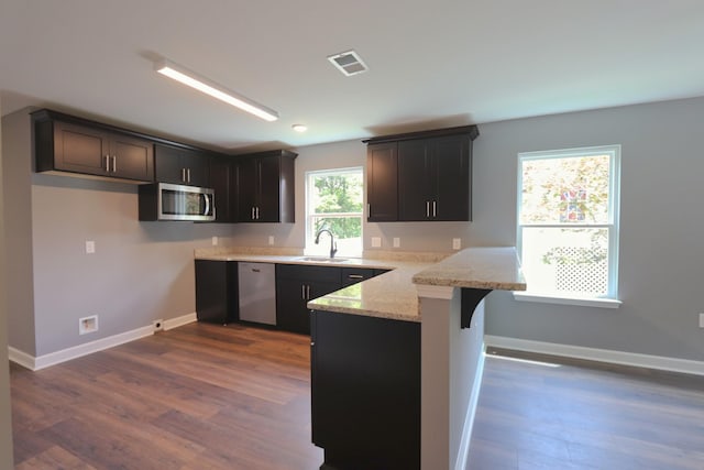 174 Dale St, Red Boiling Springs, TN 37150 - kitchen with stainless steel appliances, a peninsula, light stone counters, dark wood-style floors, and a breakfast bar