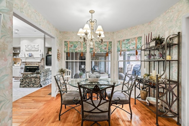 5544 S New Hope Rd, Hermitage, TN 37076 - dining area featuring wallpapered walls, wood finished floors, a chandelier, a fireplace, and ornamental molding