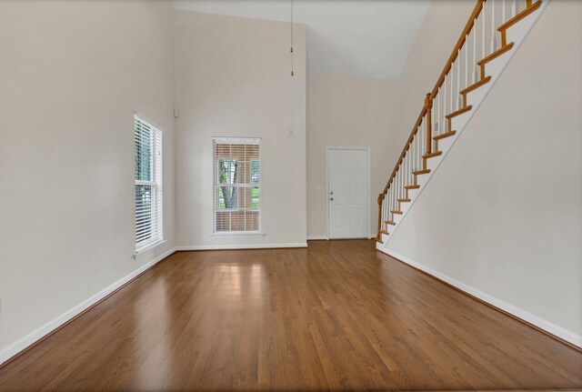4008 Amber Way, Spring Hill, TN 37174 - unfurnished living room with a towering ceiling, stairs, baseboards, and wood finished floors