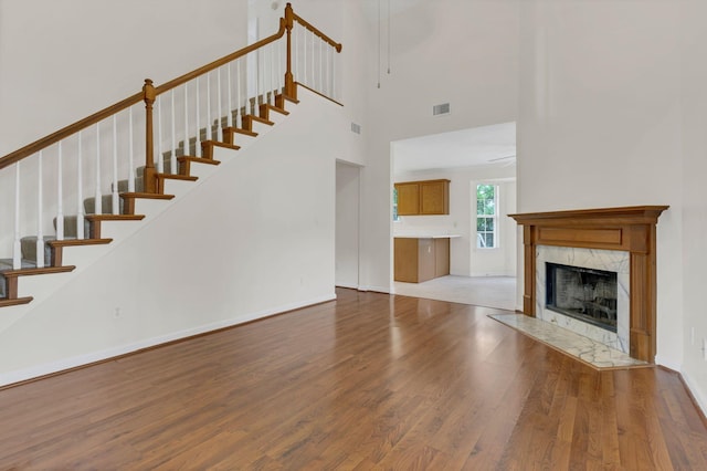 4008 Amber Way, Spring Hill, TN 37174 - unfurnished living room featuring wood finished floors, stairway, a high ceiling, a premium fireplace, and baseboards