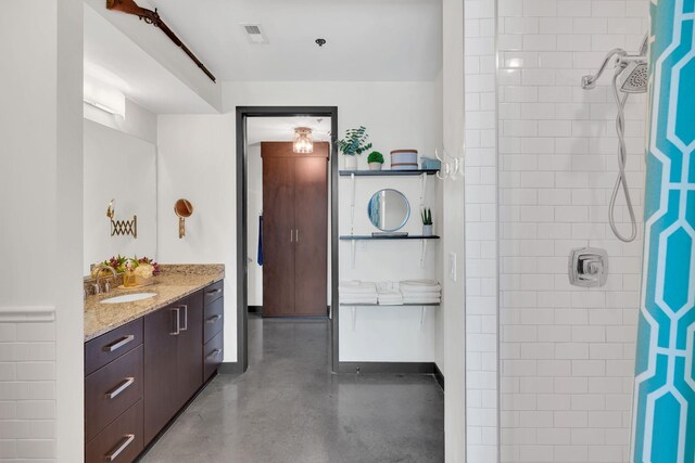 1510 Demonbreun St Unit 810, Nashville, TN 37203 - bathroom featuring vanity, tiled shower, and finished concrete flooring