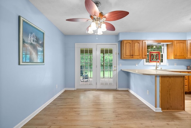 332 Meadowbrook Dr, Cadiz, KY 42211 - kitchen with light countertops, light wood-style floors, brown cabinets, and baseboards