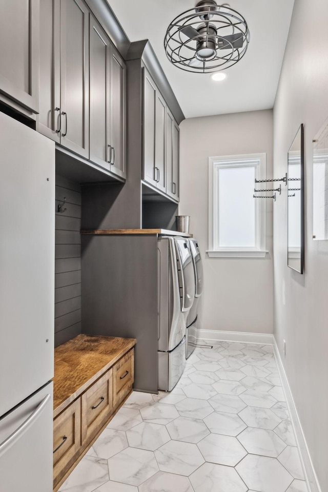807 Caledonian Ct, Franklin, TN 37064 - washroom featuring washing machine and dryer, light marble finish flooring, baseboards, a ceiling fan, and cabinet space