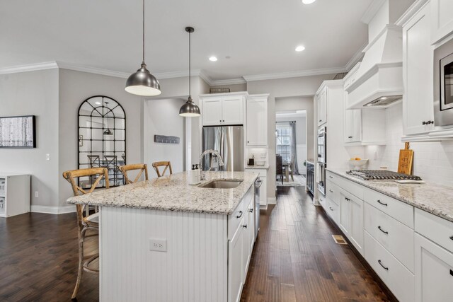 807 Caledonian Ct, Franklin, TN 37064 - kitchen with appliances with stainless steel finishes, a sink, a kitchen bar, dark wood-style floors, and recessed lighting
