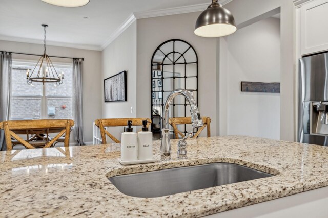 807 Caledonian Ct, Franklin, TN 37064 - kitchen with a chandelier, a sink, light stone countertops, crown molding, and decorative light fixtures