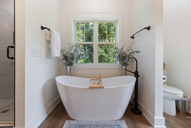 5660 Bold Springs Rd, Mc Ewen, TN 37101 - bathroom featuring wood finished floors, a stall shower, a soaking tub, and baseboards