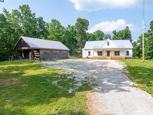 5660 Bold Springs Rd, Mc Ewen, TN 37101 - view of front of property with metal roof, a front yard, driveway, and an outbuilding