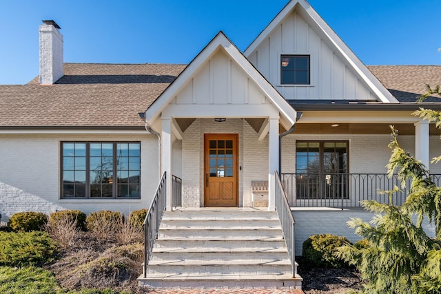 6115 Hillsboro Pike, Nashville, TN 37215 - view of front of house with brick siding, board and batten siding, a shingled roof, a chimney, and covered porch