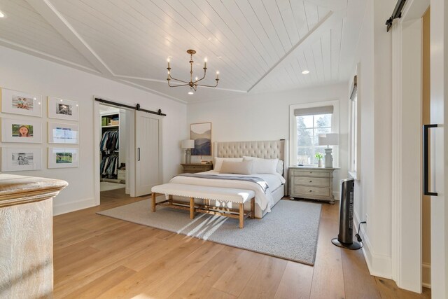 6115 Hillsboro Pike, Nashville, TN 37215 - bedroom with a barn door, wood ceiling, light wood-type flooring, a walk in closet, and a chandelier