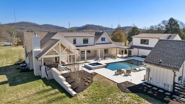 6115 Hillsboro Pike, Nashville, TN 37215 - back of property featuring board and batten siding, an outdoor living space, a yard, a patio area, and a pool with connected hot tub
