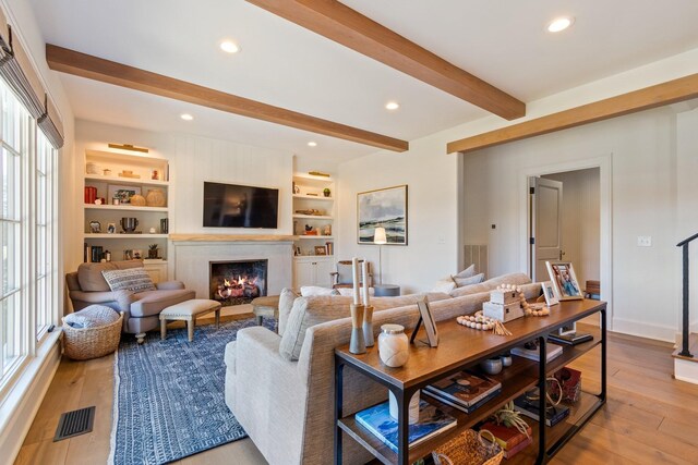 6115 Hillsboro Pike, Nashville, TN 37215 - living area featuring a warm lit fireplace, beamed ceiling, wood finished floors, recessed lighting, and built in shelves
