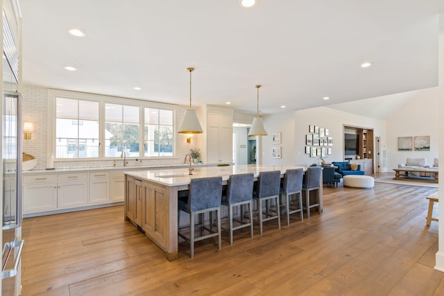 6115 Hillsboro Pike, Nashville, TN 37215 - kitchen with a sink, a large island, light wood-style flooring, tasteful backsplash, and recessed lighting