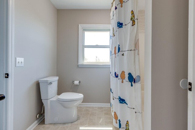 1410 Wall St, Murfreesboro, TN 37130 - bathroom featuring toilet, baseboards, and a shower with shower curtain