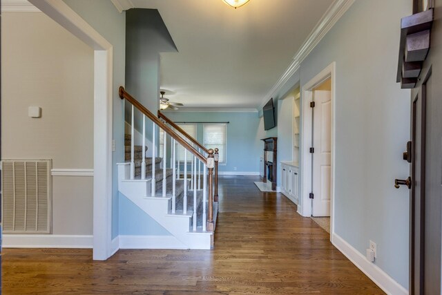 1410 Wall St, Murfreesboro, TN 37130 - entrance foyer with stairway, crown molding, a ceiling fan, a fireplace, and dark wood-type flooring