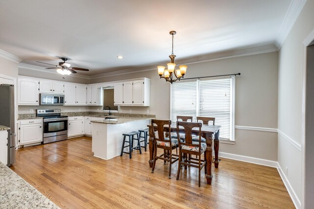 1410 Wall St, Murfreesboro, TN 37130 - kitchen featuring appliances with stainless steel finishes, a chandelier, a peninsula, crown molding, and white cabinets