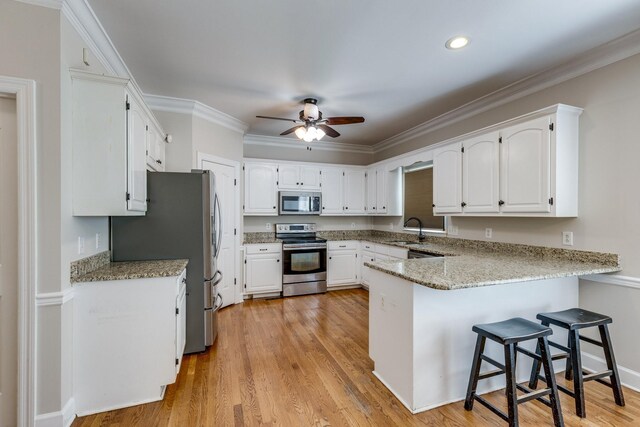 1410 Wall St, Murfreesboro, TN 37130 - kitchen featuring stainless steel appliances, a peninsula, ceiling fan, a sink, and white cabinets