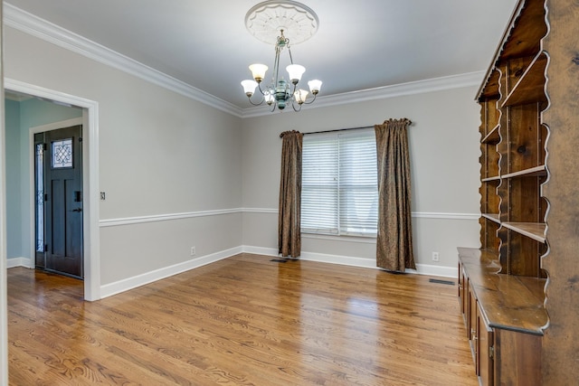 1410 Wall St, Murfreesboro, TN 37130 - spare room with a chandelier, crown molding, wood finished floors, and baseboards