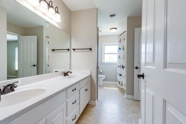 1410 Wall St, Murfreesboro, TN 37130 - bathroom featuring toilet, double vanity, baseboards, and a shower with shower curtain