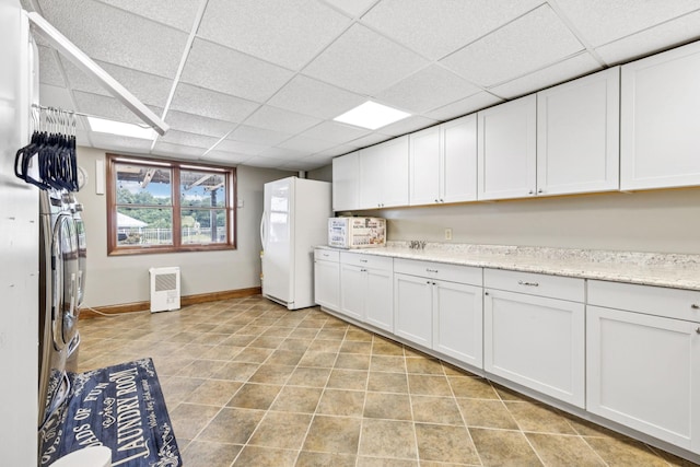 2797 Lewis Rd, Santa Fe, TN 38482 - kitchen featuring freestanding refrigerator, a drop ceiling, white cabinets, baseboards, and light stone counters