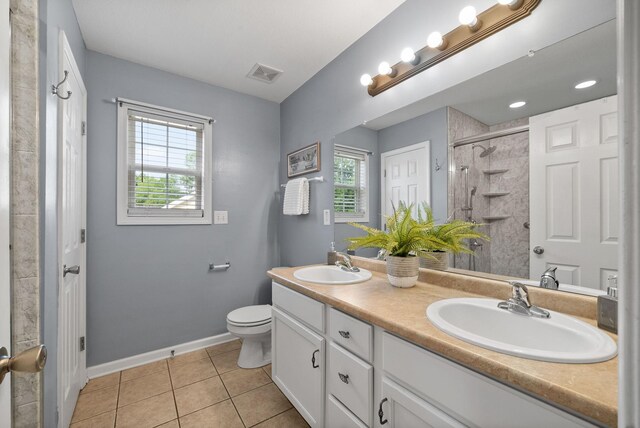 3129 Brook Hill Dr, Clarksville, TN 37042 - bathroom featuring double vanity, tile patterned flooring, a tile shower, toilet, and baseboards
