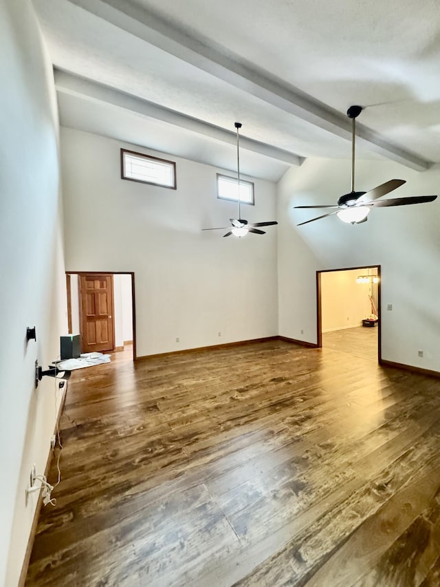 841 Mccord Hollow Rd, Hohenwald, TN 38462 - unfurnished living room featuring ceiling fan, wood finished floors, beam ceiling, high vaulted ceiling, and baseboards