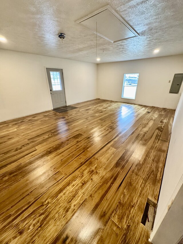 841 Mccord Hollow Rd, Hohenwald, TN 38462 - spare room featuring attic access, wood-type flooring, and a textured ceiling