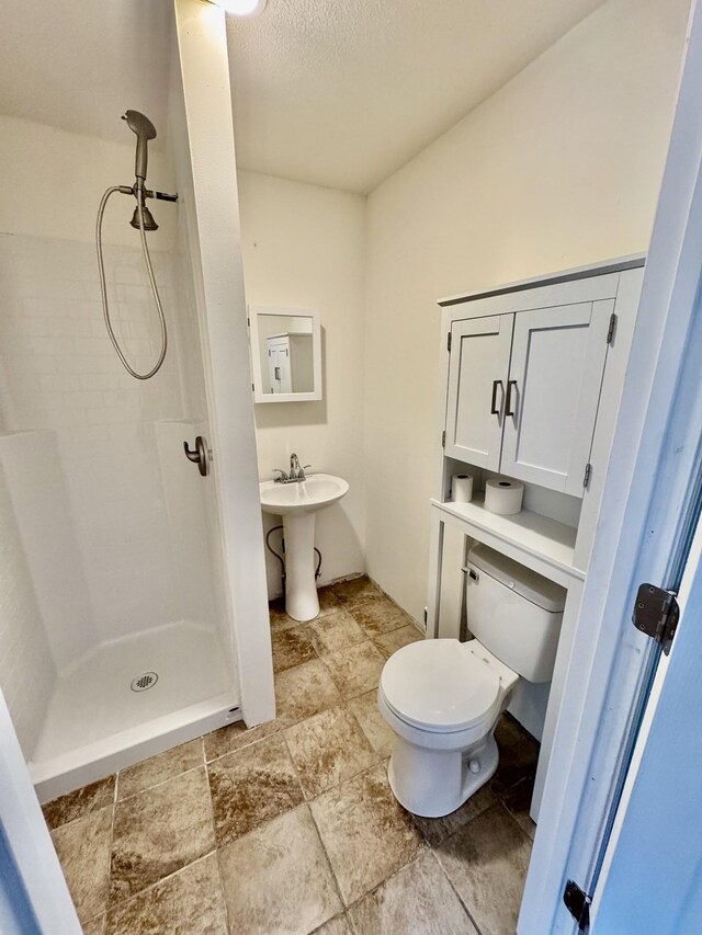 841 Mccord Hollow Rd, Hohenwald, TN 38462 - bathroom featuring a shower stall, toilet, a textured ceiling, and stone finish flooring