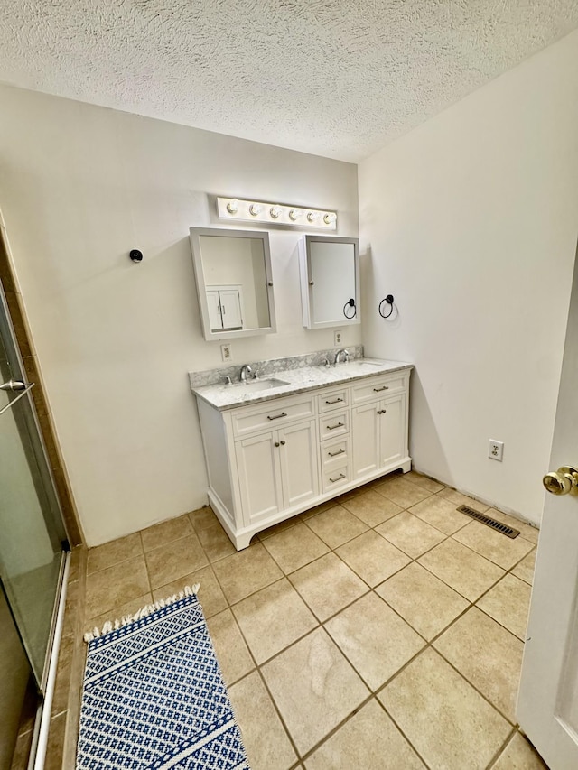 841 Mccord Hollow Rd, Hohenwald, TN 38462 - full bathroom with double vanity, tile patterned flooring, a textured ceiling, and a shower with door