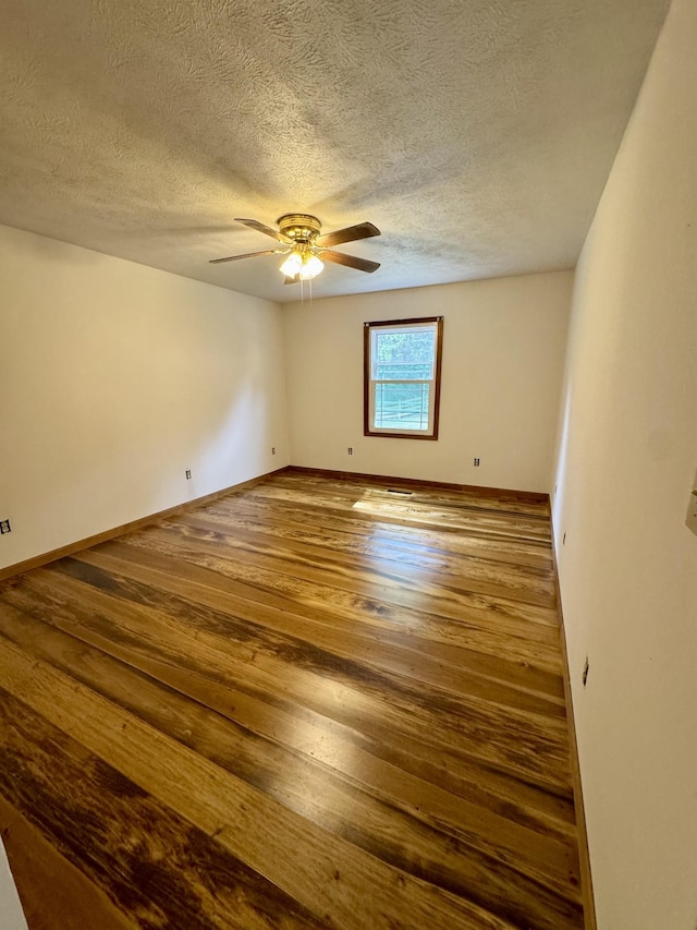 841 Mccord Hollow Rd, Hohenwald, TN 38462 - unfurnished room with wood finished floors, a textured ceiling, a ceiling fan, and baseboards