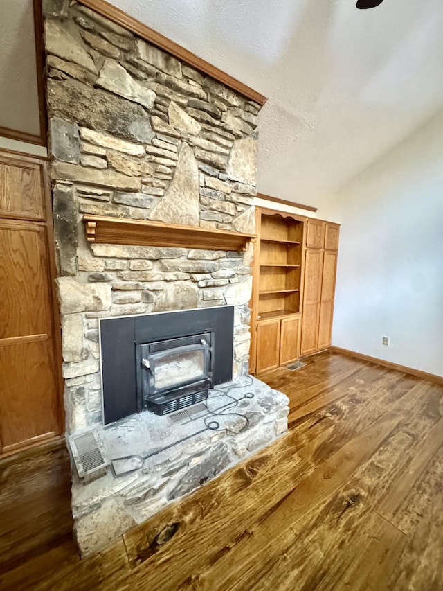 841 Mccord Hollow Rd, Hohenwald, TN 38462 - unfurnished living room with dark wood finished floors, baseboards, a stone fireplace, and lofted ceiling