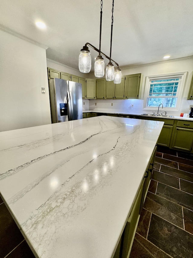 841 Mccord Hollow Rd, Hohenwald, TN 38462 - kitchen with stainless steel fridge, light stone counters, a sink, green cabinetry, and hanging light fixtures