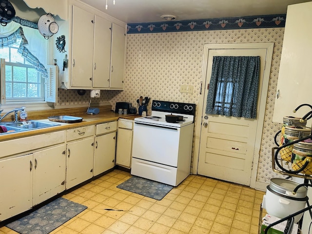 1102 Manor Rd, Columbia, TN 38401 - kitchen with white electric stove, wallpapered walls, a sink, and light floors