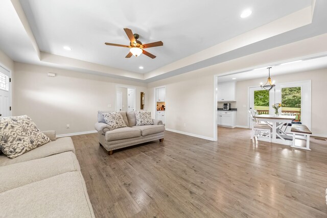2034 Glencoe Rd, Culleoka, TN 38451 - living room featuring a raised ceiling, light wood-style floors, ceiling fan, recessed lighting, and a chandelier