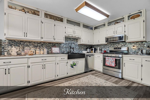 81 Pine Tree Cir, Crossville, TN 38571 - kitchen featuring appliances with stainless steel finishes, a sink, white cabinetry, light countertops, and light wood finished floors
