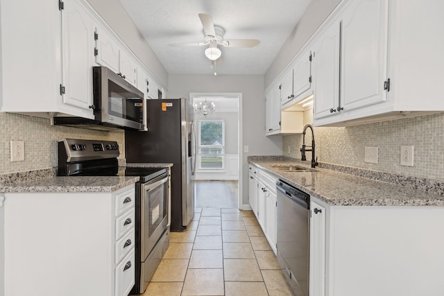 3540 Lake Towne Dr, Antioch, TN 37013 - kitchen with appliances with stainless steel finishes, a sink, white cabinetry, a ceiling fan, and backsplash