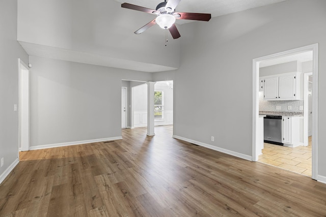 3540 Lake Towne Dr, Antioch, TN 37013 - unfurnished living room featuring decorative columns, ceiling fan, light wood-type flooring, high vaulted ceiling, and baseboards