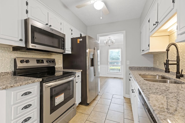 3540 Lake Towne Dr, Antioch, TN 37013 - kitchen with stainless steel appliances, a sink, white cabinetry, a ceiling fan, and wainscoting
