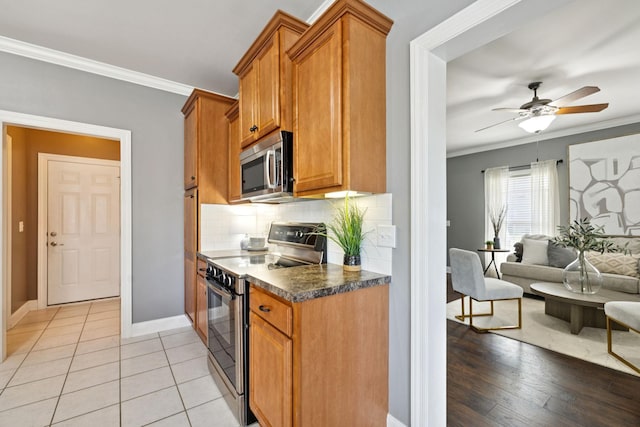 5239 Starnes Dr, Murfreesboro, TN 37128 - kitchen featuring appliances with stainless steel finishes, ornamental molding, dark countertops, brown cabinets, and baseboards
