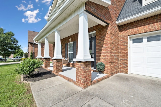 5239 Starnes Dr, Murfreesboro, TN 37128 - view of exterior entry with brick siding, a porch, concrete driveway, a shingled roof, and an attached garage